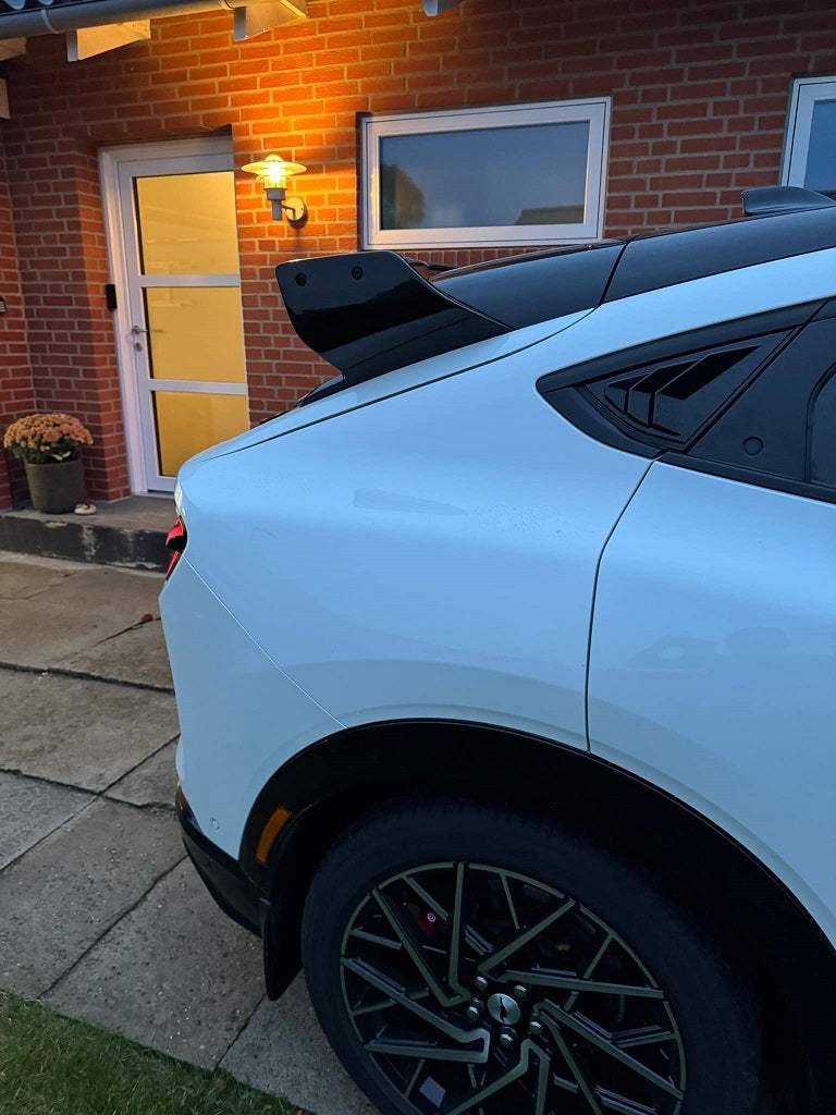 Rally Wing Spoiler on white Ford Mustang Mach-E, carbon fiber aerodynamic rear wing enhancing stability and sporty look.