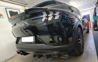 Rear diffuser on black 2021-2025 Mustang Mach-E in garage with American flag background