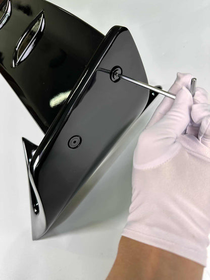 Close-up of person wearing white gloves installing a black Rally Wing Spoiler for Ford Mustang Mach-E using a screwdriver
