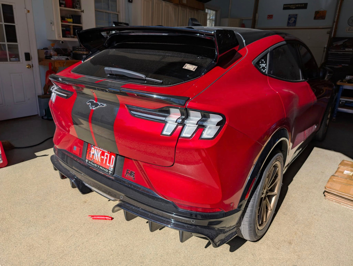 Red Ford Mustang Mach-E with black Rally Wing Spoiler installed on rear for enhanced aerodynamics and sporty look