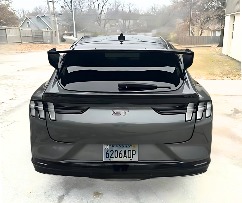 Rear view of a black Ford Mustang Mach-E GT with a sleek black Rally Wing Spoiler installed, enhancing its aerodynamic design and sporty appearance.